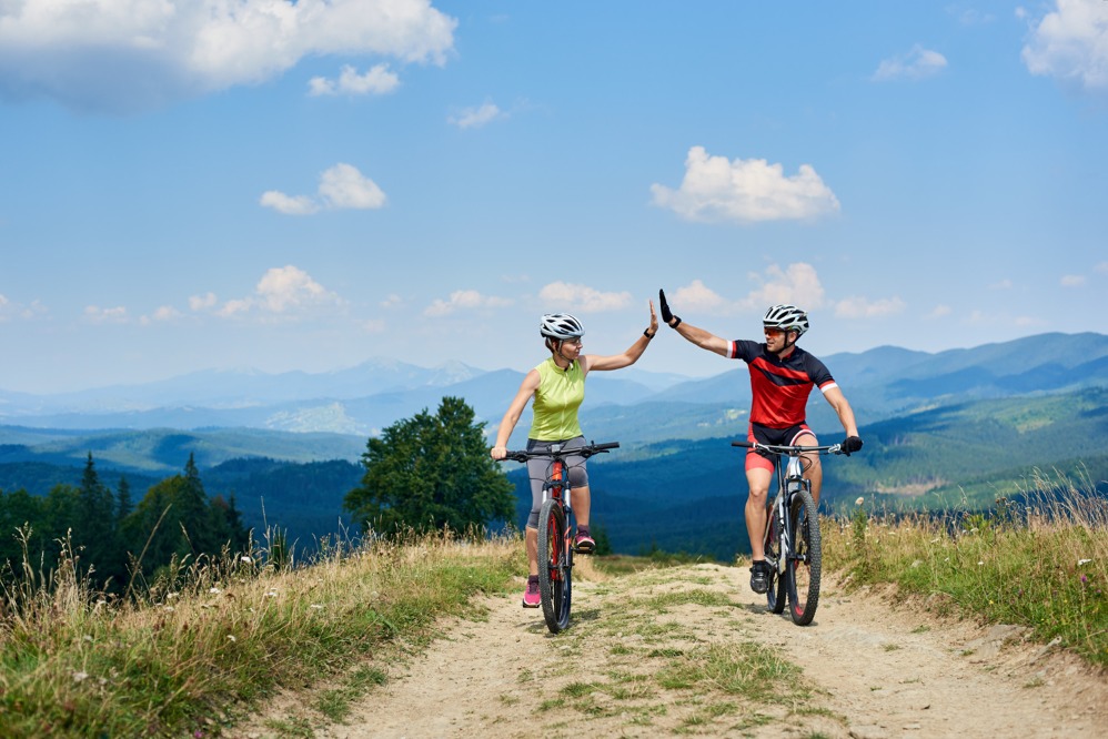 happy-couple-bicyclists-riding-cross-country-bicycles-mountain-road-sunny-summer-day-carpathians-active-man-woman-giving-each-other-high-five.jpg